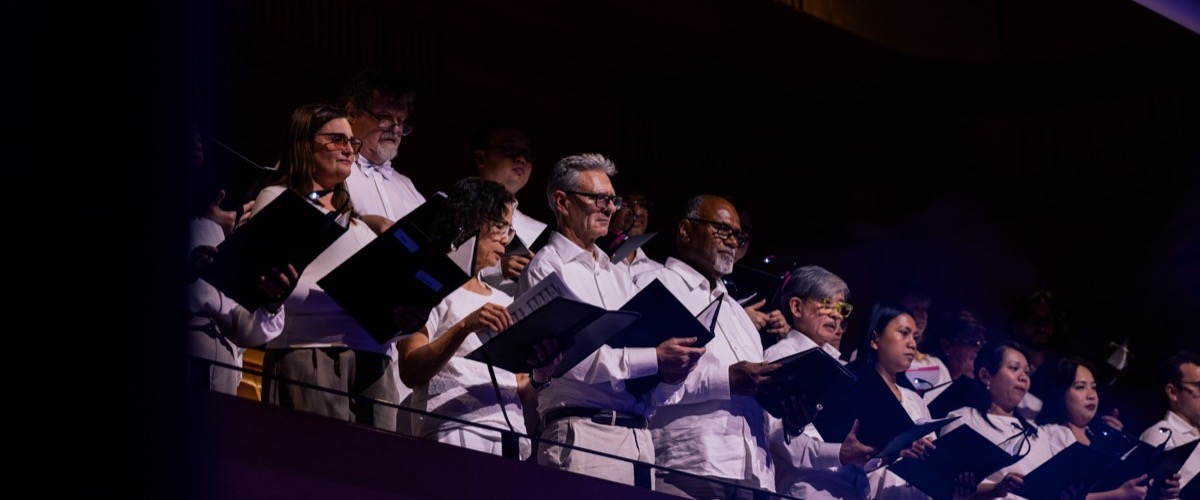Graph depicts a group of people singing in harmony, holding black music stands.