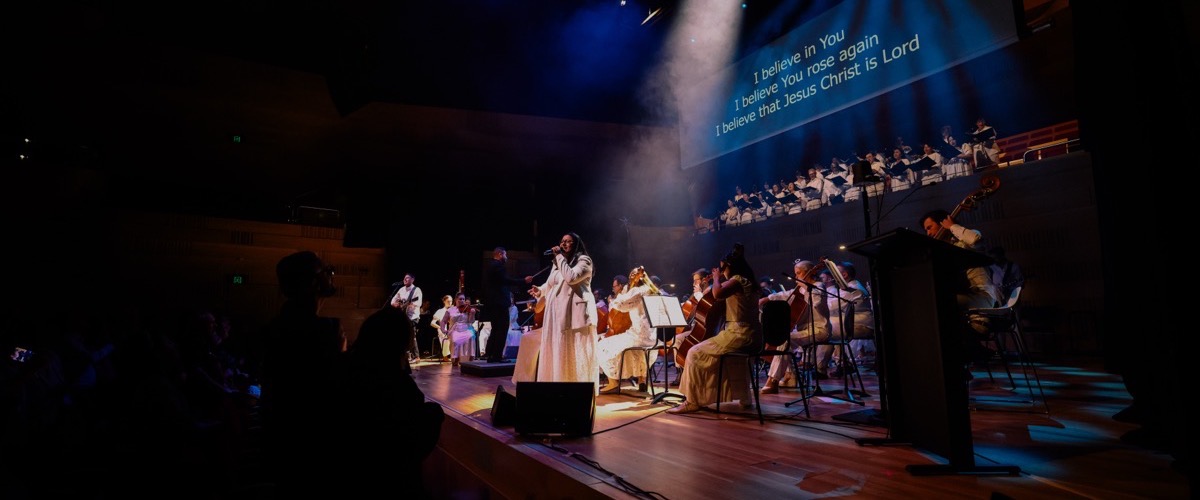 Graph depicts a group of musicians and singers performing on stage in front of an audience.