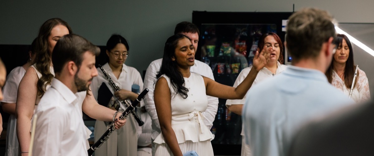 Graph depicts a group of people gathered in a room, with some holding musical instruments and others wearing white attire.