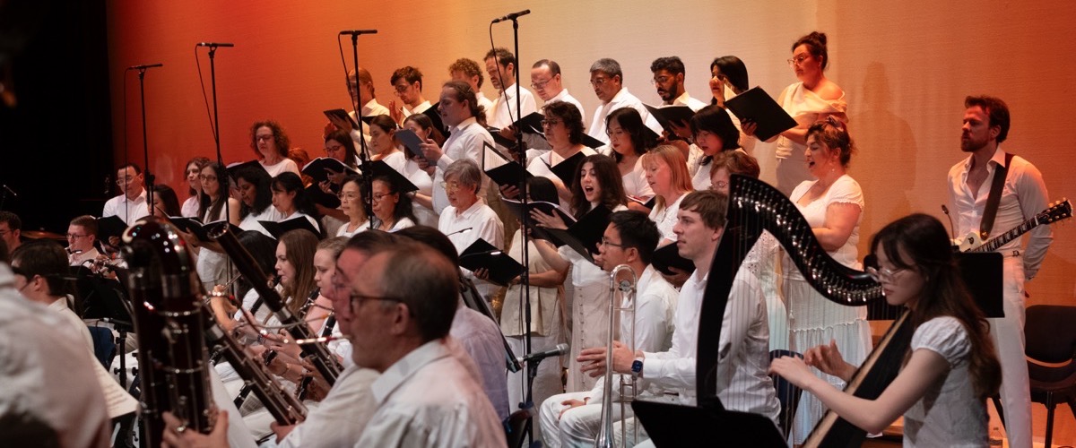 A group of musicians and singers performing on stage, likely at a concert or show.